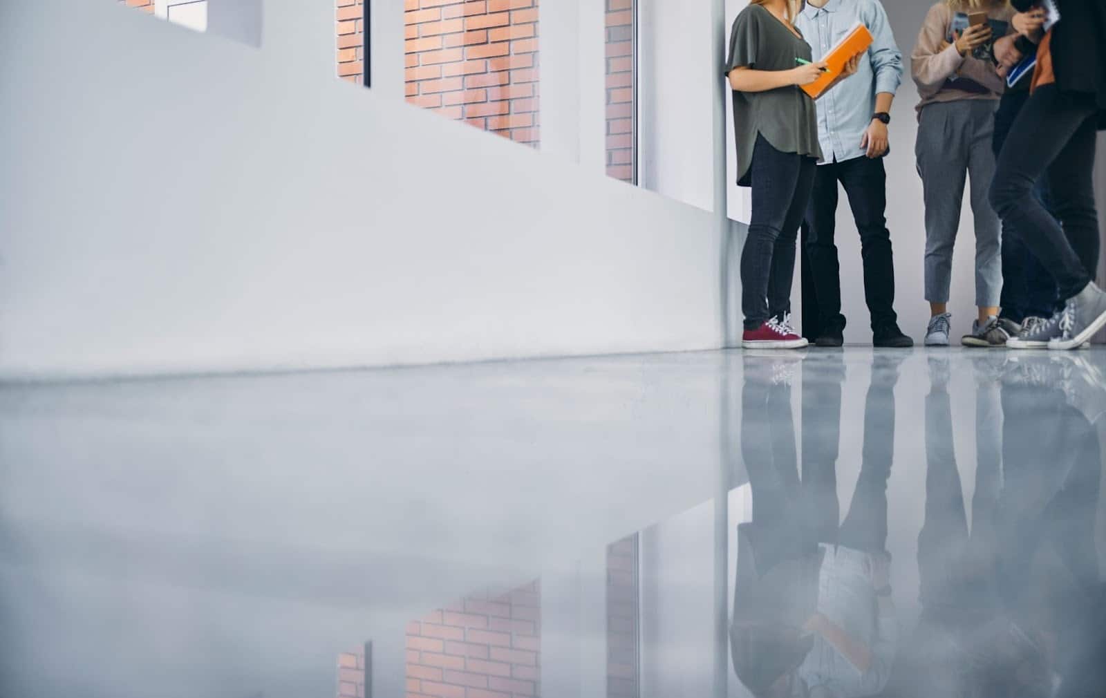 Students standing in a bright school hallway with smooth epoxy flooring