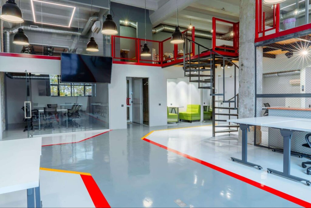 Spacious modern office interior with polished epoxy flooring in a bright open-plan layout.